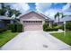 Home featuring a well-kept lawn, pruned hedges, and a two-car garage at 519 Catalina Isles Cir, Venice, FL 34292