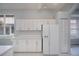 View of kitchen with white cabinetry and appliances, including fridge with water dispenser at 519 Catalina Isles Cir, Venice, FL 34292