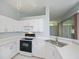 Corner view of kitchen with white cabinets, stainless sink, and modern appliances at 519 Catalina Isles Cir, Venice, FL 34292