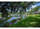 Scenic pond view with lush landscaping and reflection of neighborhood homes under a blue sky at 519 Catalina Isles Cir, Venice, FL 34292