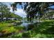 Scenic pond view with lush landscaping and reflection of neighborhood homes under a blue sky at 519 Catalina Isles Cir, Venice, FL 34292