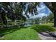 Scenic pond view with lush landscaping and reflection of neighborhood homes under a blue sky at 519 Catalina Isles Cir, Venice, FL 34292