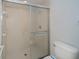 Tiled walk-in shower with glass doors and white tile floor at 519 Catalina Isles Cir, Venice, FL 34292