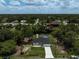 Aerial view of a quaint home with a screened pool, backing onto a serene waterway with a wooden dock at 5306 Maccaughey Dr, North Port, FL 34287