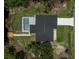 Aerial view of a home with a screened pool, set by a waterway featuring a wooden dock at 5306 Maccaughey Dr, North Port, FL 34287