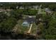 Areal view of backyard featuring a screened pool and waterway with a wooden dock, nestled in lush surroundings at 5306 Maccaughey Dr, North Port, FL 34287