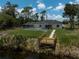 Beautiful backyard view with screened pool and wooden dock next to a serene waterway, perfect for relaxation at 5306 Maccaughey Dr, North Port, FL 34287