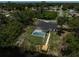 Beautiful backyard view showcasing a screened pool and a wooden dock by the water, set against lush greenery at 5306 Maccaughey Dr, North Port, FL 34287