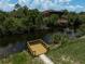 Lush backyard featuring a peaceful pond with a new wooden dock, and a gazebo in the distance at 5306 Maccaughey Dr, North Port, FL 34287