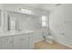 Bathroom featuring a white vanity with ample storage, large mirror, and updated fixtures at 5306 Maccaughey Dr, North Port, FL 34287