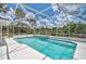 A screened-in pool with clear blue water sits surrounded by lush greenery under a bright, partly cloudy sky at 5306 Maccaughey Dr, North Port, FL 34287