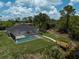Backyard view of a screened-in pool and a personal wooden dock over a waterway at 5306 Maccaughey Dr, North Port, FL 34287
