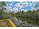 Scenic view of a tranquil waterway with lush greenery, captured from a charming wooden deck under a blue sky at 5306 Maccaughey Dr, North Port, FL 34287