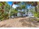 Expansive backyard featuring mature trees and a glimpse of the home's exterior and pool area at 5369 Shadow Lawn Dr, Sarasota, FL 34242
