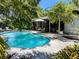 Inviting in-ground pool surrounded by mature trees, patio, and screened-in area, perfect for outdoor living at 5369 Shadow Lawn Dr, Sarasota, FL 34242