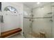 The bathroom features a glass shower with a bench, tile flooring, and a bright window at 5818 Harrison Rd, Venice, FL 34293