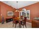 Formal dining room featuring earth-tone walls, tile flooring, chandelier, and a bright window with shutters at 5818 Harrison Rd, Venice, FL 34293