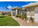 Charming home with a screened-in porch, manicured lawn, and walkway leading to the front door at 5818 Harrison Rd, Venice, FL 34293