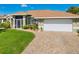 Well-maintained home with a two-car garage, screened entry, and professionally landscaped yard at 5818 Harrison Rd, Venice, FL 34293