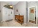 Bright foyer with tile flooring, double doors, and a decorative cabinet adds charm to the home at 5818 Harrison Rd, Venice, FL 34293