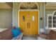Inviting home entry with yellow double doors, seating, and neutral accents create a warm welcome at 5818 Harrison Rd, Venice, FL 34293