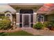 Charming home exterior with a screened-in porch and stone pathway amidst lush landscaping at 5818 Harrison Rd, Venice, FL 34293