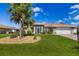 Charming single-story home featuring a well-manicured lawn and a picturesque palm tree in a beautifully landscaped front yard at 5818 Harrison Rd, Venice, FL 34293