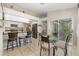 Bright kitchen with stainless appliances, tile floors, breakfast bar and dining area with sliding glass door at 5818 Harrison Rd, Venice, FL 34293