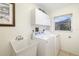 Well-lit laundry room with a utility sink, washer and dryer, and ample storage at 5818 Harrison Rd, Venice, FL 34293