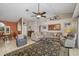Bright living room features a vaulted ceiling, comfortable seating, and an eye-catching rug on tile flooring at 5818 Harrison Rd, Venice, FL 34293