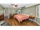 Bright main bedroom with a ceiling fan, wood-look flooring, and a view to the en suite bathroom at 5818 Harrison Rd, Venice, FL 34293