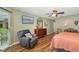 Spacious main bedroom with a view to the lanai, ceiling fan, wood-look flooring, and neutral paint at 5818 Harrison Rd, Venice, FL 34293