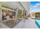 The covered patio includes comfortable seating adjacent to the screened-in pool at 5818 Harrison Rd, Venice, FL 34293