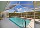 Sparkling pool in a screened enclosure, surrounded by lush landscaping at 5818 Harrison Rd, Venice, FL 34293