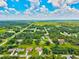 Expansive aerial view of the community showcasing lush greenery and neighborhood layout under a cloudy blue sky at 5954 Gottfried Ln, North Port, FL 34291