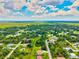 Vast aerial view of homes nestled among lush trees and greenery beneath a blue sky with scattered clouds at 5954 Gottfried Ln, North Port, FL 34291