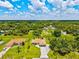 An aerial view captures a charming home with a well-manicured lawn in a lush, green neighborhood at 5954 Gottfried Ln, North Port, FL 34291