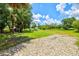 Spacious backyard featuring lush grass, scattered trees, and an open sky in a serene setting at 5954 Gottfried Ln, North Port, FL 34291