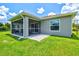 Back exterior view of home with screened in patio and grassy lawn at 5954 Gottfried Ln, North Port, FL 34291