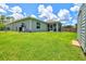 Expansive backyard featuring lush green grass, screened lanai, and a neatly maintained exterior at 5954 Gottfried Ln, North Port, FL 34291