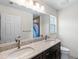 Bathroom features double sinks, granite countertops, large mirror, and a window for natural light at 5954 Gottfried Ln, North Port, FL 34291