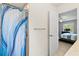 Bathroom with shower featuring an artistic blue shower curtain and a view into the bedroom at 5954 Gottfried Ln, North Port, FL 34291
