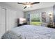 Bedroom features a ceiling fan, tile flooring, and a cozy nautical themed quilt with decorative lamps at 5954 Gottfried Ln, North Port, FL 34291