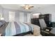 This bedroom features light grey walls, a ceiling fan, and a modern entertainment center with a large television at 5954 Gottfried Ln, North Port, FL 34291