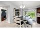 Bright dining area showcases a modern chandelier, custom shelving, and a sliding glass door to the patio at 5954 Gottfried Ln, North Port, FL 34291