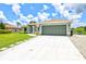 Charming single-story home featuring a well-manicured lawn, large garage, and welcoming walkway at 5954 Gottfried Ln, North Port, FL 34291