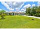 Well-maintained home with green lawn, mature landscaping and long driveway at 5954 Gottfried Ln, North Port, FL 34291