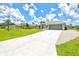Single story home with a long concrete driveway and well-manicured lawn at 5954 Gottfried Ln, North Port, FL 34291