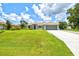 Charming single-story home featuring a lush green lawn and a two car attached garage at 5954 Gottfried Ln, North Port, FL 34291
