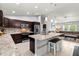 Beautiful kitchen with stainless appliances, granite counters, island, and adjacent living room with plush seating at 5954 Gottfried Ln, North Port, FL 34291